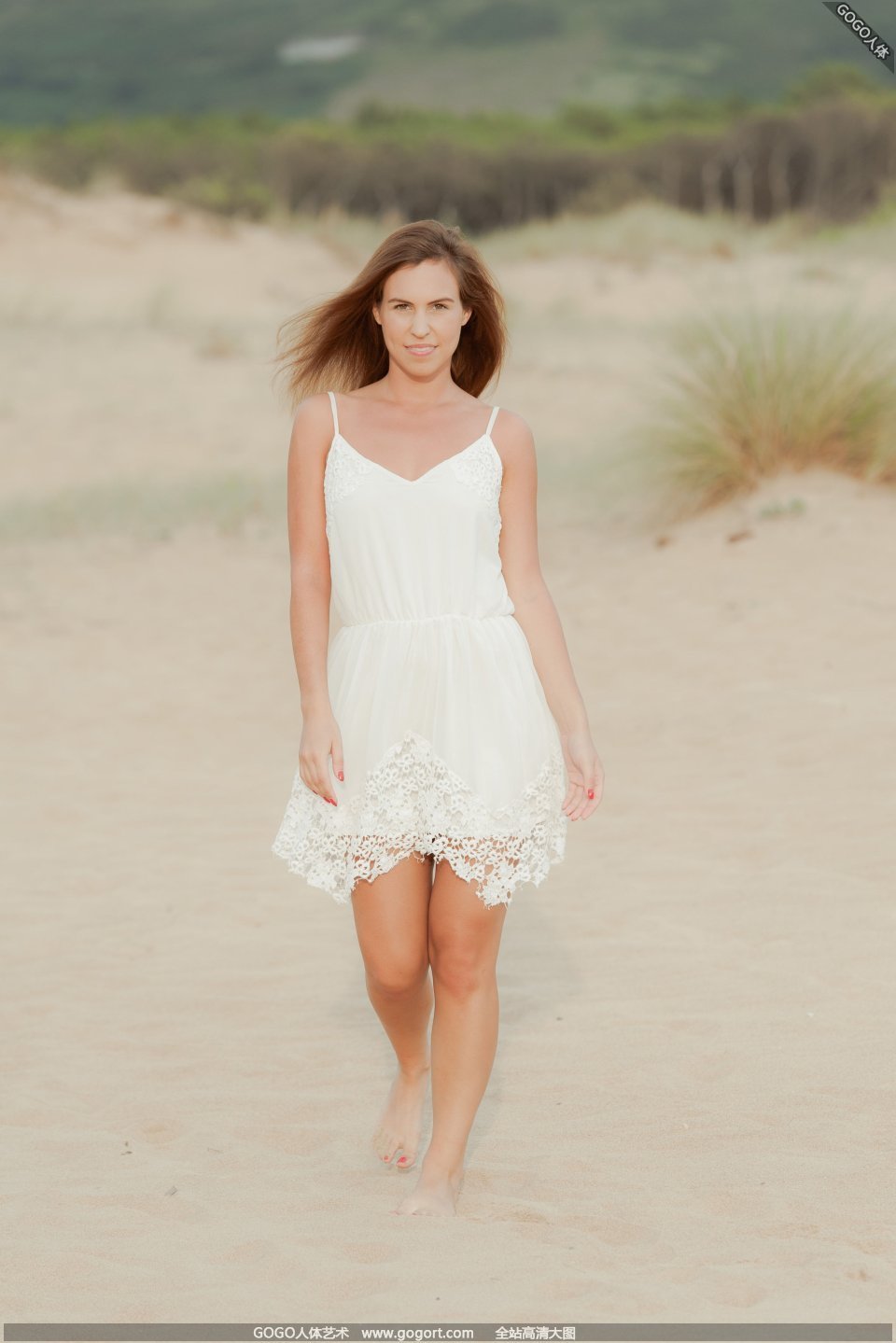 Model JENNYA who breaks holes on the sand dunes 
