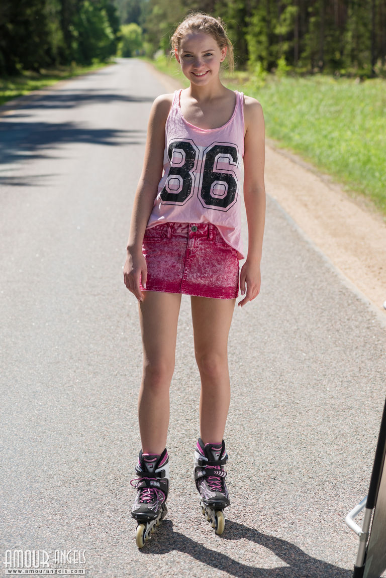 年轻的金发女孩Faina穿着旱冰鞋在路中间赤身裸体